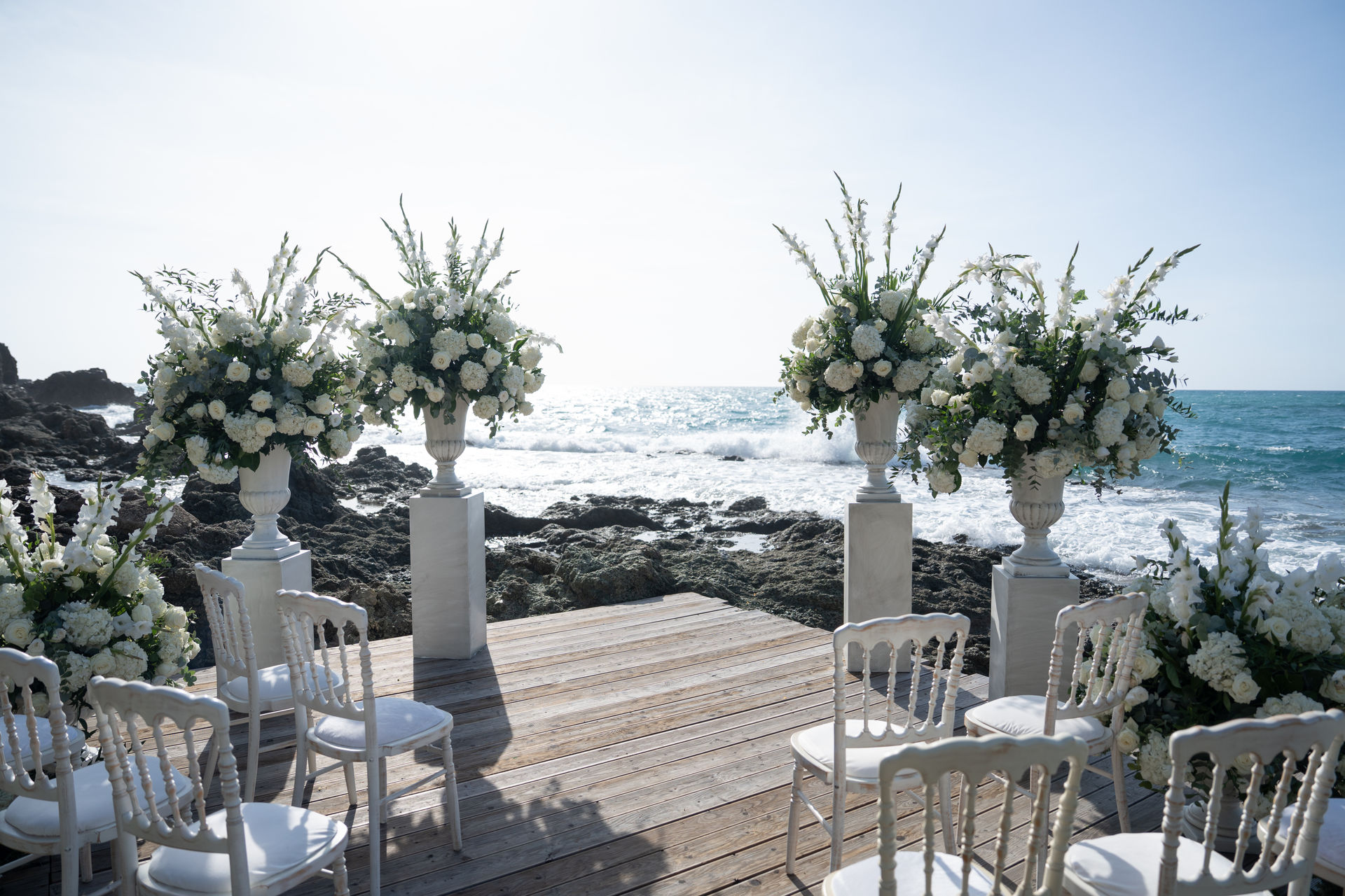 A luxury wedding setup on a platform on the coast of Italy, overlooking the Mediterranean Sea